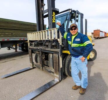 Treated Lumber Products | BB&S Lumber Worker with arm resting on forklift | BB&S Lumber